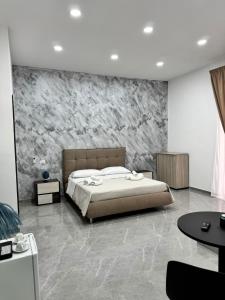 a bedroom with a bed and a stone wall at Il Ritrovo Spa&Rooms in Naples