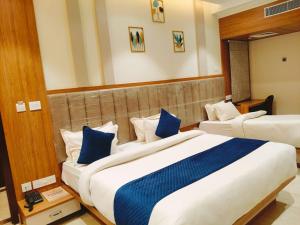 a hotel room with two beds with blue pillows at Hotel Banaras Villa in Kakarmatha