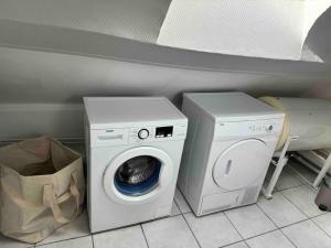 a washer and a washing machine in a room at Appart centre ville in La Loupe