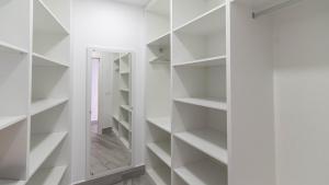 a walk in closet with white shelves and a mirror at El Soberano El Gastor by Ruralidays in El Gastor
