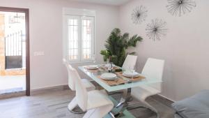 a dining room with a table and white chairs at El Soberano El Gastor by Ruralidays in El Gastor