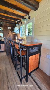 una cucina con un bancone con sedie e un tavolo di Tiny House El Barco a El Hoyo