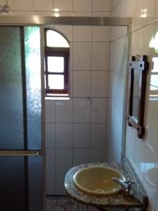 un bagno con lavandino e doccia di Casa Vivenda dos Bem-te-vis a Monte Verde Altre 27 foto