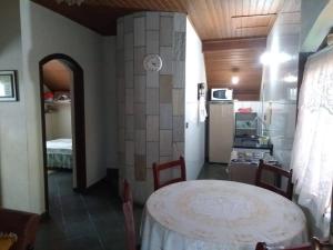 una sala da pranzo con un tavolo e una cucina di Casa Vivenda dos Bem-te-vis a Monte Verde