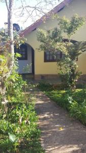 una casa con un passaggio pedonale davanti di Casa Vivenda dos Bem-te-vis a Monte Verde