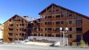 un gran edificio de apartamentos con balcones de madera. en RISOUL 1850, en Risoul