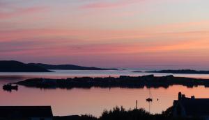 a sunset over a large body of water at Aultbea Lodges in Aultbea