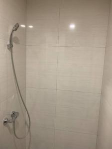 a shower in a bathroom with a white tile wall at COMFORTSTAY-Citra Plaza Nagoya #31-06 Sea View in Jodoh +7 photos