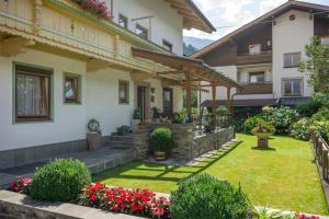una casa con giardino fiorito in cortile di Gästehaus Kopp a Stumm