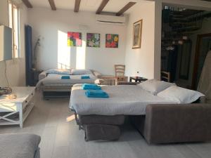a room with two beds and a couch at Mansarda Teatro Duse Centro in Bologna