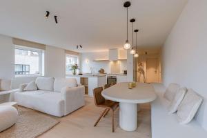 een woonkamer en keuken met een tafel en een bank bij Huswell - Luxurious apartment on top location in Knokke in Knokke-Heist