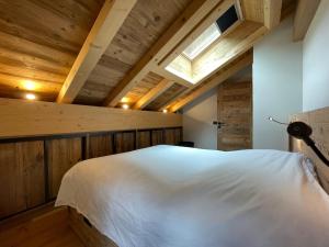 圣索林达尔沃Appartement duplex neuf en hyper centre station - 6 personnes的卧室配有一张白色大床和天窗