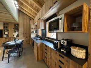 圣索林达尔沃Appartement duplex neuf en hyper centre station - 6 personnes的厨房配有木制橱柜和桌椅