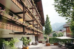 a building with a patio with chairs and plants at Martinerhof's Brauhotel in San Martino