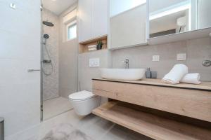 a bathroom with a sink and a toilet and a shower at Villa Nova Excellence 1, villa with private pool in Novalja