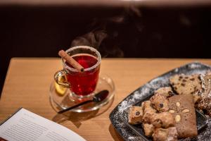 a glass cup of tea next to a plate of food at Boutique Hotel Atrium München in Munich