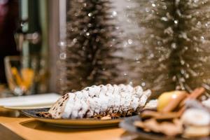 a dessert on a plate on a table with a christmas tree at Boutique Hotel Atrium München in Munich