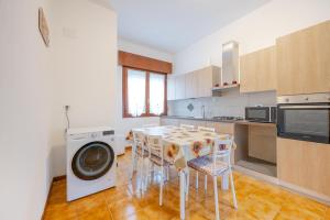 cocina con mesa y lavadora en Tatiana Flat - 10 minutes to Venice - Mestre Train Station - Free Parking, en Venecia 11 fotos más