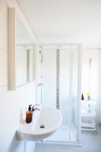 a white bathroom with a sink and a shower at bel appartement tout juste rénové in Vierzon