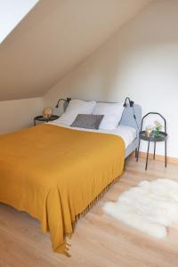 a bedroom with a bed with a yellow blanket at bel appartement tout juste rénové in Vierzon