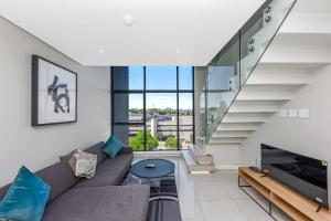 a living room with a couch and a staircase at Park Central Residence - Building with Generator in Johannesburg