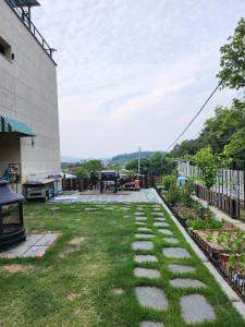 a garden with grass and stones in front of a building at Kong's heyri pet-friendly in Paju