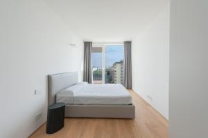 Un dormitorio blanco con una cama y una ventana. en The Summer Houses Immobiliare Pacella, en Lido di Jesolo 8 fotos más