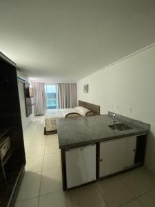 a bathroom with a sink and a bedroom with a bed at Blue Sunset Suites in Penha +3 photos