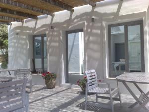 a patio with two chairs and a table and windows at Olivemare in Katelios