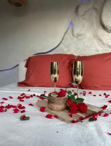 a bed with roses and two glasses of wine at Casa Amor in Fretin