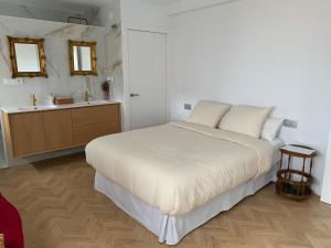 a white bedroom with a bed and a sink at Las Murallas in Baeza
