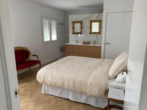 a bedroom with a bed and a bathroom with a sink at Las Murallas in Baeza