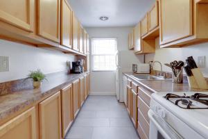 a kitchen with wooden cabinets and a white refrigerator at Stylish Corporate Apartment in Alexandria in Alexandria