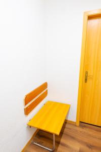 a yellow bench sitting in a room next to a door at Golden River in Unterseen