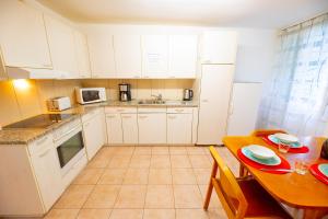 a kitchen with white cabinets and a wooden table at Golden River in Unterseen
