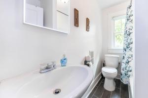 a white bathroom with a sink and a toilet at 6 Bedroom Duplex Sleeps 14 Close to Lucas Downtown in Indianapolis +55 photos