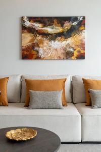 a living room with a couch with a painting at Maravilhas II by An Island Apart in Funchal +29 photos