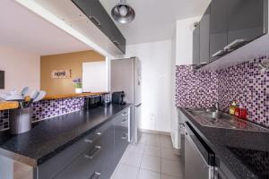 una cucina con ripiani neri in una stanza di S4 Disney Family a Serris