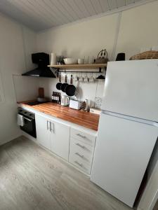 a kitchen with white cabinets and a white refrigerator at Nina casa de playa in Balneario Buenos Aires +18 photos