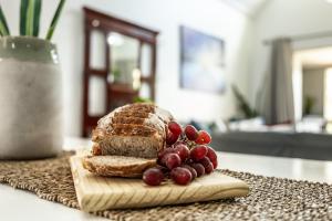 a loaf of bread and grapes on a cutting board at The Bridge Unit 8 in St Lucia