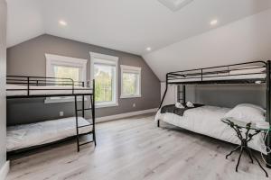 two bunk beds in a room with wooden floors at Cozy Retreat w Hot Tub Bruce Peninsula in Stokes Bay