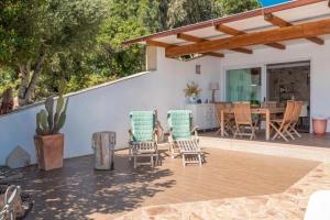 een patio met 2 stoelen en een tafel en een eetkamer bij Villa Asfodelo a Valle Dell' Erica in Valle Dell’Erica