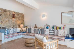 een woonkamer met banken en een stenen muur bij Villa Asfodelo a Valle Dell' Erica in Valle Dell’Erica