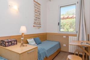 een kleine slaapkamer met een bed en een raam bij Villa Asfodelo a Valle Dell' Erica in Valle Dell’Erica