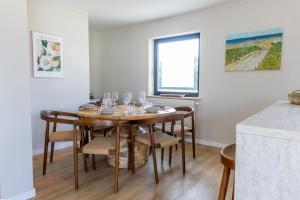 ein Esszimmer mit einem Tisch und Weingläsern darauf in der Unterkunft Huswell - Family stay with Garden & Sauna in Cadzand