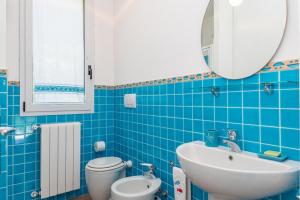 een blauw betegelde badkamer met een wastafel en een toilet bij Villa Asfodelo a Valle Dell' Erica in Valle Dell’Erica +21 foto's