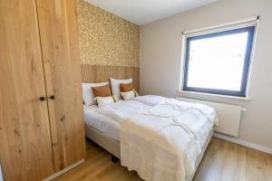A bed or beds in a room at Huswell - Charming Apartment with Garden & Parking