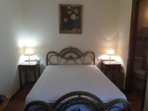 a bedroom with a bed with two lamps on two tables at Casa Rural Cendal in Navacarros