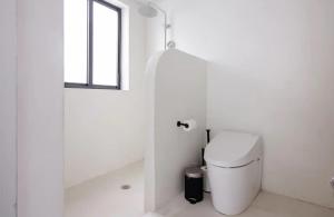 Un baño blanco con inodoro y ventana. en Atelier Lumi - at lumicollection, en Miami 23 fotos más