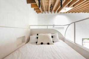 Un dormitorio con una cama blanca con un osito de peluche encima. en Atelier Lumi - at lumicollection, en Miami